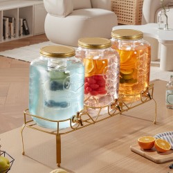 Lasinen juoma-annostelija kolmella kahdeksan litran säiliöllä metallijalustalla ruostumaton hana infuserilla