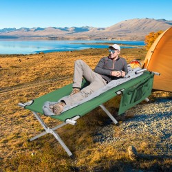 Taitettava vihreä retkisänky sivutaskulla ja kantolaukulla