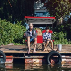 Kaksipaikkainen punainen campingtuoli aurinkosuojalla ja kantolaukulla