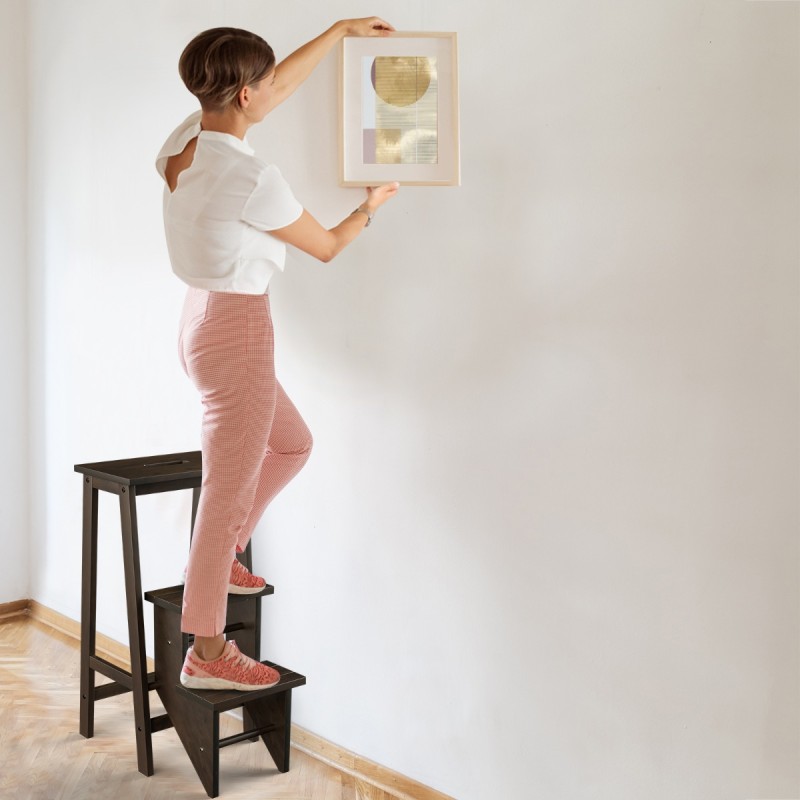 Kolmiportainen kokoontaitettava ruskea jakkara kantokahvalla ja kääntyvillä askelmilla