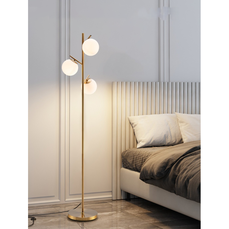 Kolmilamppuinen kultainen lattiavalaisin lasivarjostimilla ja jalkakytkimellä